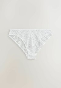 Culotte bikini pour femme en dentelle blanche avec motif floral, posée à plat sur un fond neutre clair.