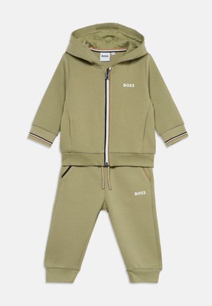 Olivengrøn toddler træningssæt med hættetrøje med lynlås og bukser med snøre, med hvide BOSS-logoer på bryst og lår.