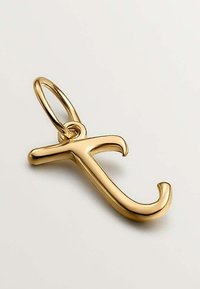 Colgante de oro en forma de letra minúscula "t" con un lazo para acoplar a una cadena o pulsera, sobre un fondo gris.