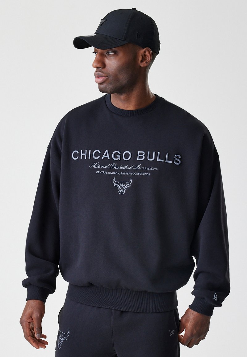 Černá mikina s nápisem "CHICAGO BULLS", logem a detaily sportovního sdružení. Dlouhé rukávy s žebrovanými manžetami a pasem.
