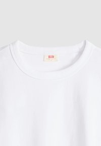 Λευκό βαμβακερό t-shirt με στρογγυλή λαιμόκοψη και απαλή υφή· διαθέτει μια μικρή κόκκινη ετικέτα "Levi's" στο λαιμό.