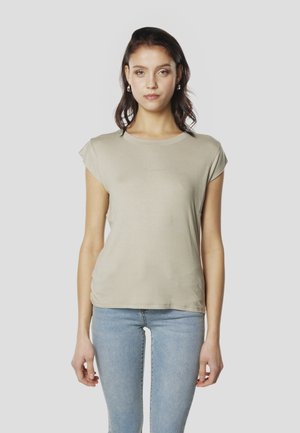 Bež kratka majica s kratkimi rokavi in okroglim izrezom, mehka tkanina in rahlo sijajna. Združena s svetlo modrimi ozkimi kavbojkami.