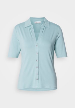 Camicia azzurra a maniche corte con colletto, scollo a V e chiusura con bottoni, realizzata in un tessuto morbido. Presenta una texture liscia e una vestibilità comoda.