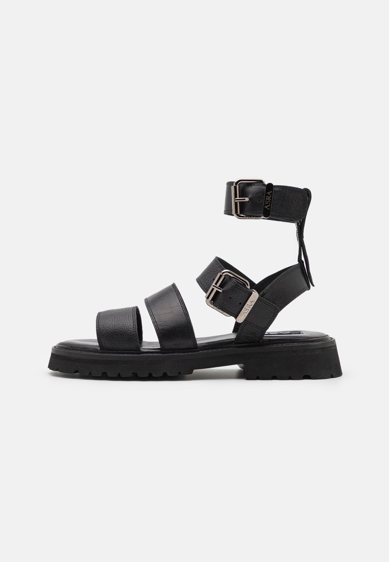 Sandale noire en cuir avec trois brides réglables à boucle et semelle épaisse, présentée en vue de profil sur fond blanc.