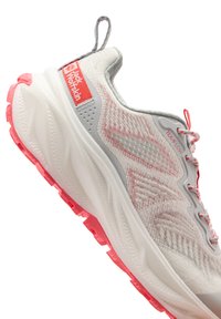 Chaussure de sport gris clair avec des accents roses. Dessus texturé, logo bien en vue, semelle rembourrée et lacets à motifs. Dispose d'une languette à l'arrière.