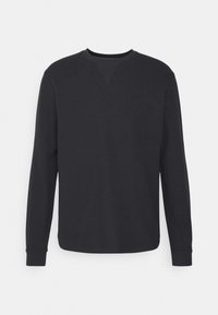 Sweat-shirt noir à col rond et manches longues avec poignets côtelés et un détail cousu subtil sous le col, sur un fond uni.