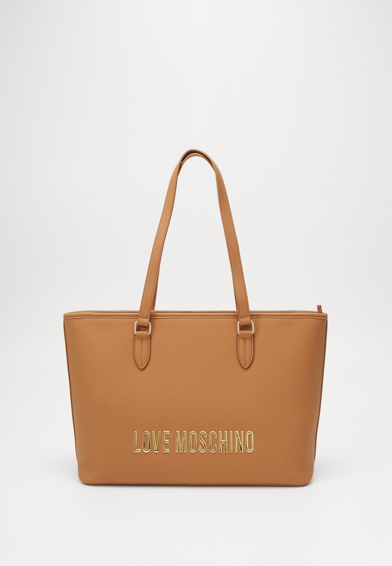 Sac fourre-tout beige avec deux poignées, texture lisse, arborant un logo doré "LOVE MOSCHINO" à l'avant, conçu pour un usage quotidien.
