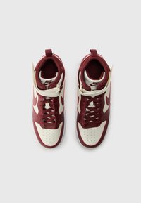 Nike visoke tenisice s gornjim dijelom od bordo kože, kremastim detaljima i teksturiranim crvenim jezikom s bijelim perforacijama na prednjem dijelu.