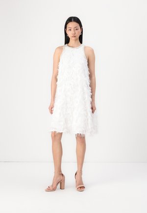 White sleeveless dress featuring a textured ruffle design. Accompanied by nude block-heeled sandals. Smooth fabric; straight silhouette.