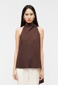 Καφέ αμάνικη μπλούζα με ψηλό λαιμό και σχέδιο με πτυχώσεις, κατασκευασμένη από λείο ύφασμα. Διαθέτει ασύμμετρο τελείωμα και άνετη γραμμή.