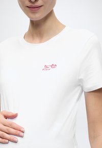 Λευκό βαμβακερό μπλουζάκι με κοντά μανίκια, στρογγυλή λαιμόκοψη και μικρό κόκκινο γραφικό με φράουλες και το κείμενο "Berry good friends."