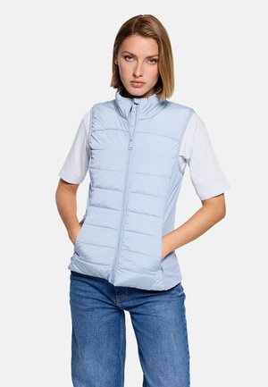 Chaleco sin mangas azul claro con cremallera frontal, acolchado horizontal y cuello alto, combinado con una camisa blanca de manga corta.