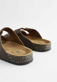 Braune Leder-Sandalen mit einer Korksohle, ausgestattet mit einem strukturierten braunen Fußbett, offenen Seiten und leichtem Design. Rutschfeste schwarze Laufsohle.