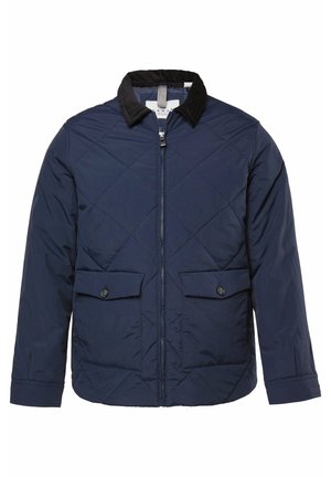 Giacca trapuntata navy con colletto in velluto a coste, zip frontale e due tasche a patta con bottone. Presenta una forma squadrata e maniche lunghe.