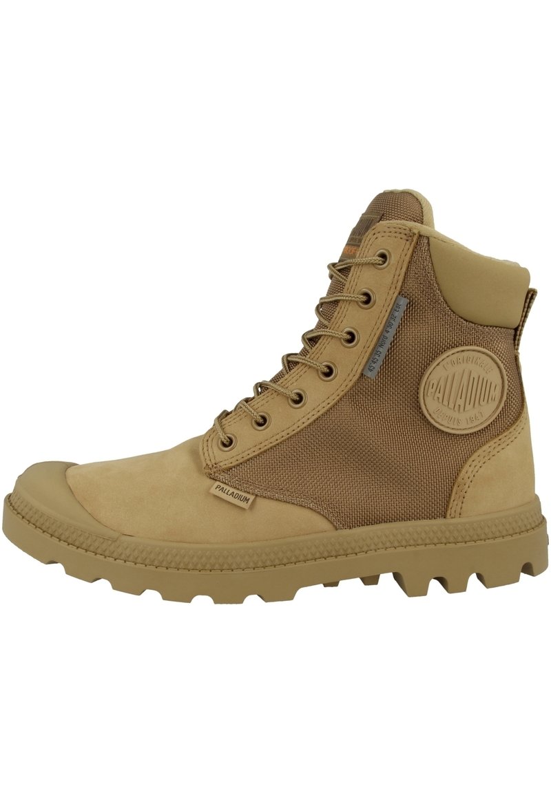 Bottine beige avec un dessus en tissu texturé et des accents en cuir lisse. Semelle en caoutchouc épaisse avec un motif de traction prononcé. Détail de logo sur le côté.