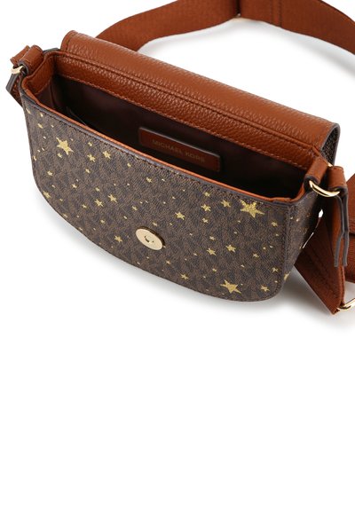 Καφέ τσάντα Michael Kors crossbody με χρυσό αστέρι σχεδίου, μαγνητικό κλείσιμο με κουμπί και ρυθμιζόμενο λουρί, εμφανίζεται ανοιχτή με ορατή εσωτερική ετικέτα.