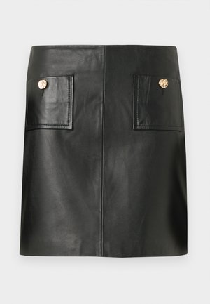 Zwarte leren mini-rok met voorste opgestikte zakken, elk afgesloten met een enkele ronde gouden knoop.