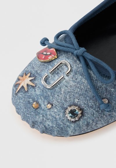 Denimová baletná botička v modrej farbe s motívmi hviezd a drahokamov, červeným akcentom v podobe pier a kovovým ozdobným sponovým detailom na vrchu.