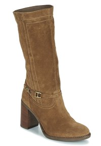 Botte hauteur genou en daim marron avec un talon carré, présentant des coutures détaillées et une bride décorative avec une boucle en laiton.