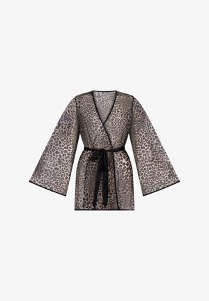 Przezroczysta bluzka kopertowa w panterkę z szerokimi rękawami i czarną lamówką, zawiązywana w talii czarną kokardą z tkaniny.