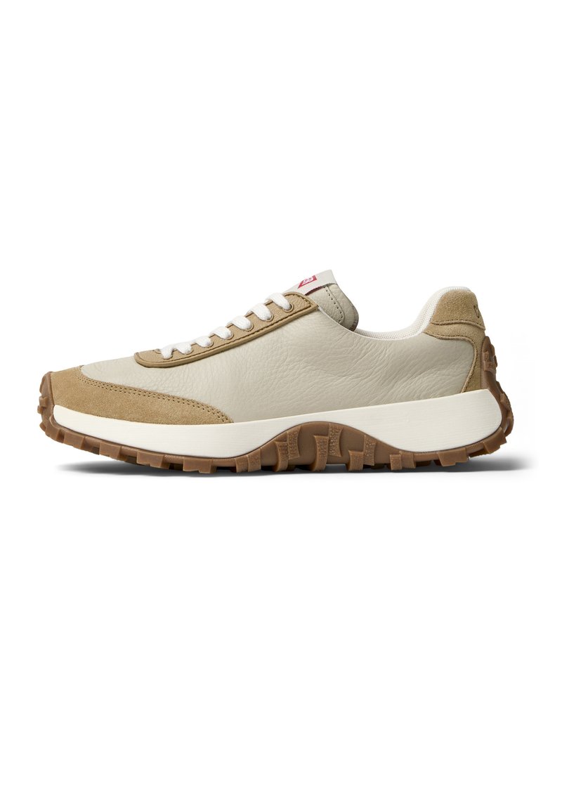 Beigen värinen nahka- ja mokkanahkainen tennari, jossa on teksturoitu pinta, valkoiset nauhat ja ruskea kumipohja, jossa on kuvioitu pito.