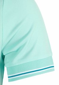 Polo shirt a maniche in verde acqua con un tessuto testurizzato e traspirante. I polsini presentano accenti a strisce bianche e turchesi.