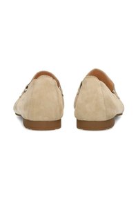 Beige suède loafers met een gladde textuur, ronde neus en een lage bruine rubberen zool. Kenmerkt zich door een subtiele stikselbewerking langs de bovenzijde.