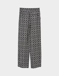 Pantalon noir à jambes larges avec motif géométrique gris circulaire et carré, fermeture éclair à l'avant et ceinture plate.