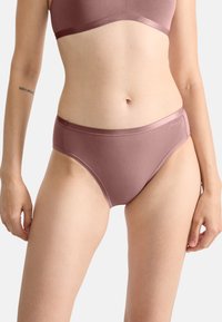 Slip bordeaux in tessuto con texture liscia e copertura media. Presenta una fascia in vita effetto satinato e un marchio discreto sul lato.