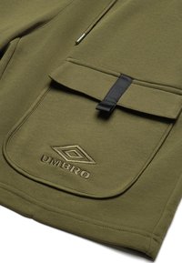 S1o1, verde măsliniu, cu o amprentă de buzunar cusută și accesorii negre, având logo-ul "Umbro" embosat pe material.