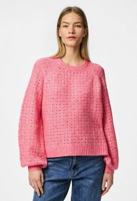 Maglione lavorato a maglia rosa con un design a trama aperta e texture, polsini e orlo a coste. Vestibilità rilassata, con colletto tondo classico e spalle scese.