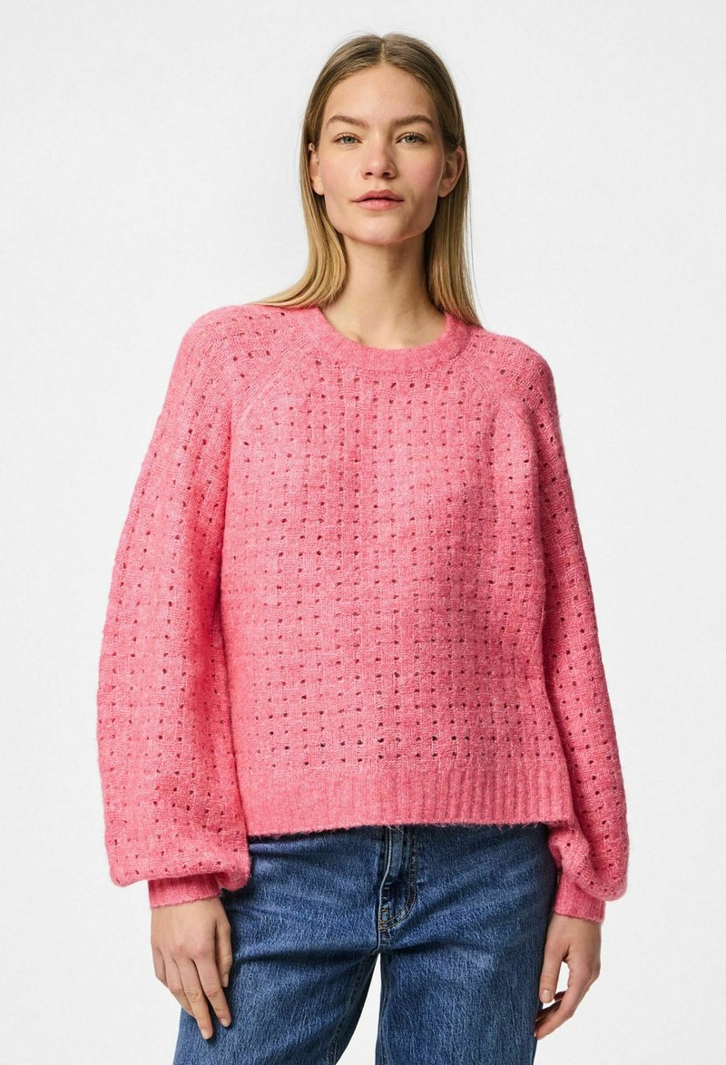 Maglione lavorato a maglia rosa con un design a trama aperta e texture, polsini e orlo a coste. Vestibilità rilassata, con colletto tondo classico e spalle scese.