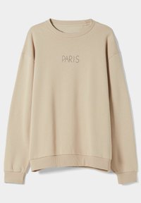 Beige sweatshirt met een geribbelde ronde hals en geribde manchetten. Op de voorkant staat in lichtgrijs de tekst "PARIS" gedrukt. Gladde textuur.