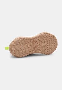 Semelle de chaussure avec un motif en caoutchouc brun texturé et durable, pr�ésentant des sculptures triangulaires et angulaires. Une languette de traction vert citron se trouve au niveau du talon.