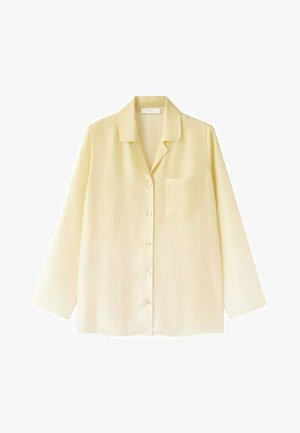 Cămașă galben deschis cu mâneci lungi, cu nasturi, cu guler și buzunar pe piept, confecționată dintr-un material texturat ușor.