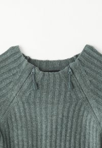 Maglione verde a coste con colletto alto, caratterizzato da cordini regolabili sul colletto, realizzato in un tessuto testurizzato.