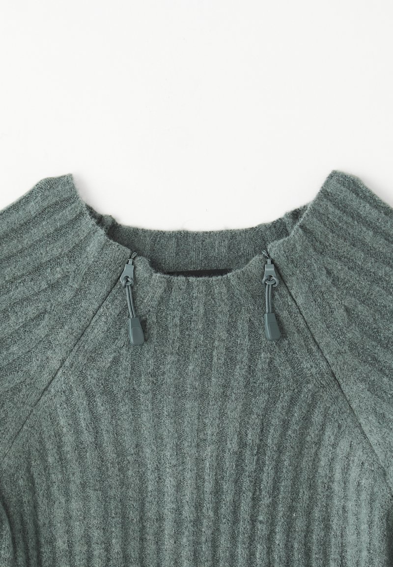 Maglione verde a coste con colletto alto, caratterizzato da cordini regolabili sul colletto, realizzato in un tessuto testurizzato.