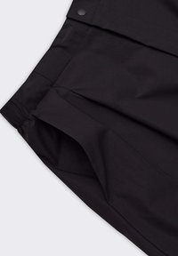 Shorts neri realizzati in tessuto leggero con una texture liscia, dotati di tasche laterali e chiusura con bottone frontale.