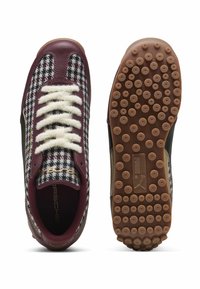 Sneaker con motivo che presentano una punta in pelle bordeaux, lacci bianchi, dettagli neri e suola in gomma texturizzata con grip circolari.