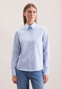Camicia a righe in azzurro chiaro con sottili righe bianche e pastello, caratterizzata da un colletto appuntito e maniche lunghe, realizzata in tessuto morbido.