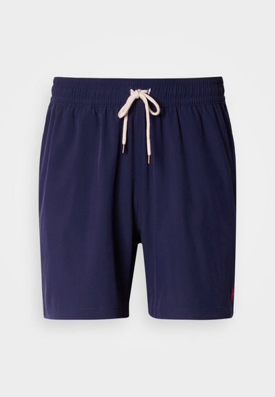 Marineblå badeshorts med elastisk midje og kremfarget snor. Har en liten logo nederst i høyre hjørne. Glatt stofftekstur.