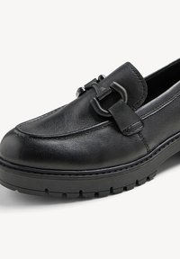 Černé kožené mokasíny s nízkou, texturední podrážkou, s dekorativní sponou a páskem přes nárt. Hladký povrch s bočním prošitím.