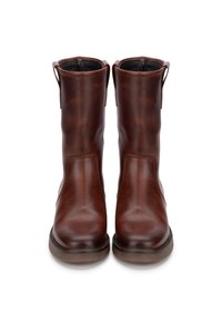 Botas de tobillo de cuero marrón con una textura suave, suela plana y pequeñas lengüetas en los lados para facilitar su uso. Diseño limpio y minimalista.