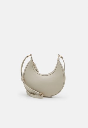 Bolso pequeño de hombro de cuero beige en forma de media luna con correa ajustable y hebilla dorada sobre fondo liso.
