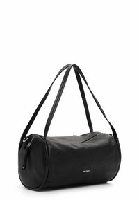 Schwarze Leder-Duffel-Tasche mit perforierter Textur, runder Form, doppelten Schultergurten und einem Reißverschluss. Silbernes Logo-Detail an der Seite.