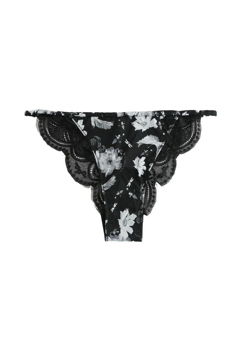 Schwarze Spitzen-Tanga mit weißen und grauen Blumenmustern, gewellten Spitzenrändern und Rüschenbesatz entlang des Bundes.