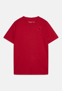 T-shirt rossa in cotone con maniche corte, colletto rotondo e piccolo logo nero sul lato sinistro del petto. Tessuto morbido e leggero con una texture liscia.