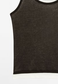 Zwart mouwloos tanktop van een textuurstof, met contrasterende witte biezen langs de halslijn en onderzoom. Eenvoudig ontwerp.