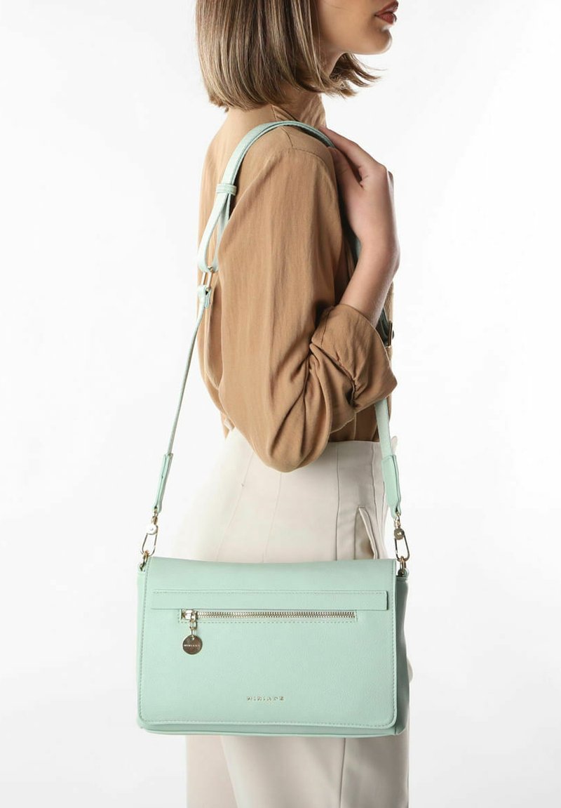 Borsa a tracolla verde menta in pelle texture con tasca frontale con zip, tracolla regolabile e dettagli metallici. Design geometrico con una silhouette semplice.