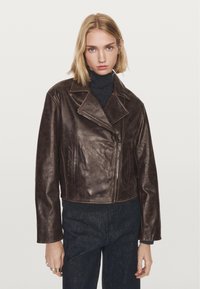 Braune Leder-Cropped-Jacke mit Reverskragen, Reißverschluss vorne und seitlichen Taschen. Glatte Textur mit dezentem Glanz und lässiger Passform.